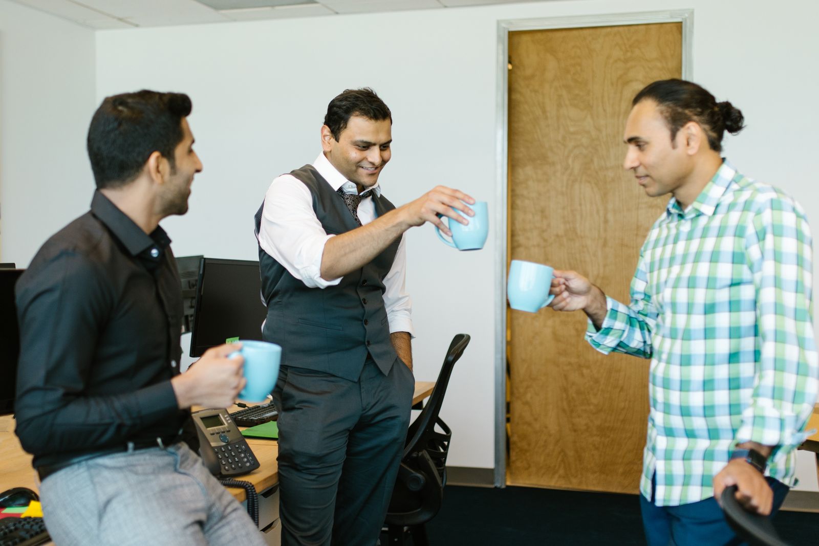 Colleagues chatting over coffee in an office